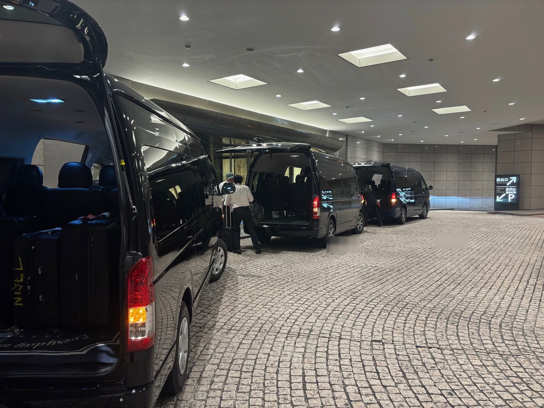 Black transportation vehicles staged at a hotel entrance