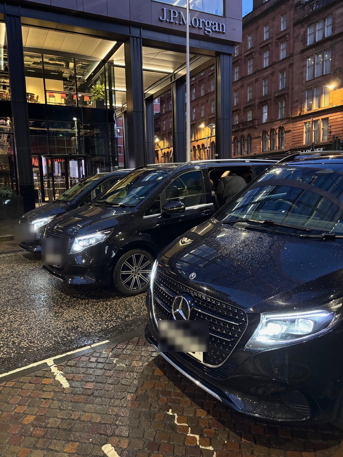 Black secure transportation vans staged curbside